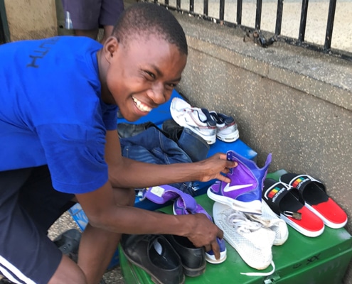 A street boy with donated shoes