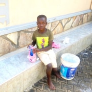 Former street child cleaning his shoes