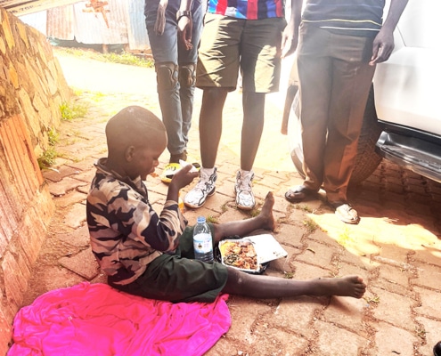 A homeless child sitting by the road in Kampala